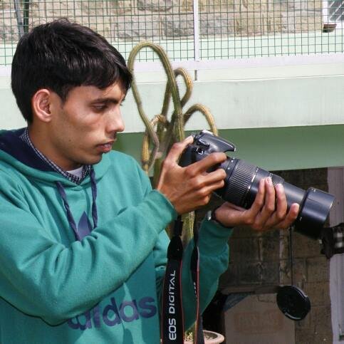 Holding Canon 1100D with Tamron lens